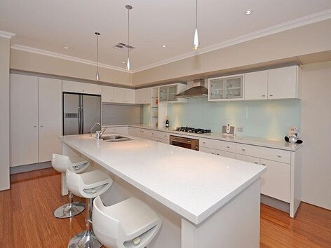 New built home with contemporary white kitchen and bar stools